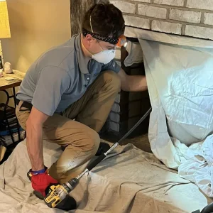 CSIA Certified Chimney Sweep using rotary power brushes for chimney cleaning in Virginia Beach.