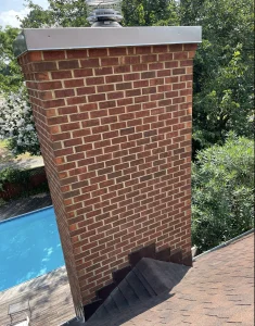 Masonry chimney in Chesapeake, VA undergoing brick repointing to repair deteriorated mortar joints and restore structural integrity.
