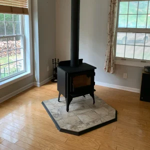 Idle freestanding stove installed in Hampton, VA on a custom tile hearth pad with proper venting through the roof.