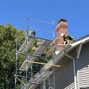 A chimney technician from Premier Chimney and Roofing setting up for a chimney relining repair.
