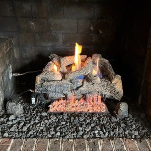 After photo of a gas fireplace in Chesapeake, VA with new gas logs and restored burner function following expert repair.