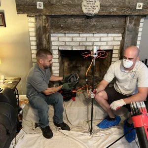 Technician preparing fireplace for chimney inspection in Newport News