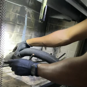 vacuuming ashes from the fireplace during a chimney sweep in Hampton, VA