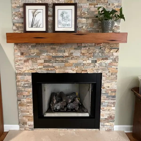 Ventless gas logs installed in a custom stacked stone fireplace with floating mantel
